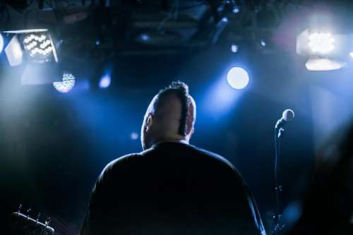 Back view of guitar player on concert stage