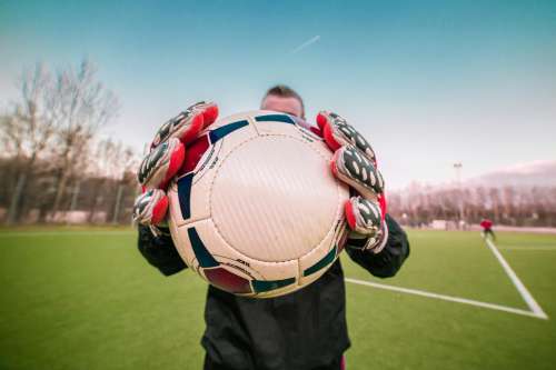 Goalkeeper holding and showing football to the camera