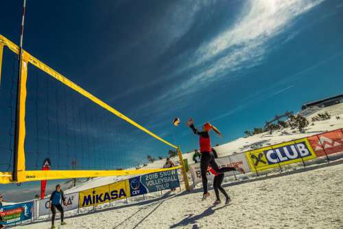 Women playing snow volleyball