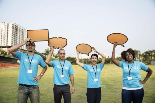 A group of multiethnicity colleagues raising various cardboard speech bubble cutouts