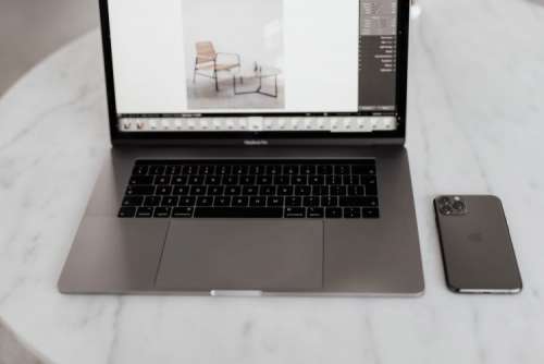 MacBook Pro 15 laptop and iPhone 11 Pro on a marble table