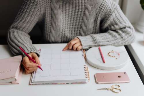 A woman writes in a calendar