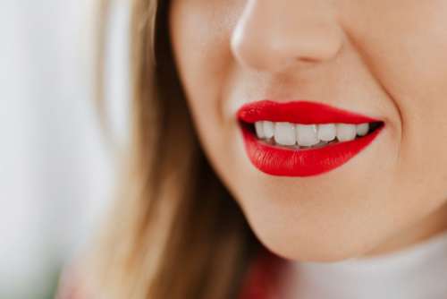 Close-up on red female lips and white teeth