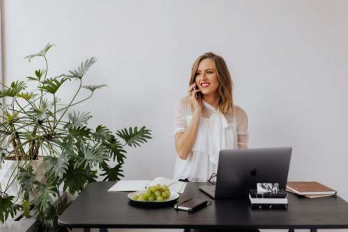 A businesswoman works at a desk with a laptop