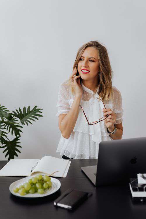 A businesswoman works at a desk with a laptop