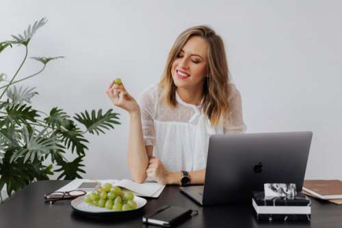 A businesswoman works at a desk with a laptop