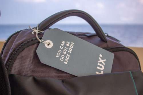 Luggage Tag Label on Suitcase or Bag with the Sea Behind It
