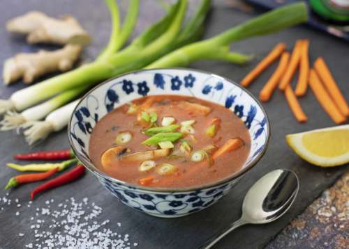 Bowl Of Soup On Table Surrounded By Vegetables Photo