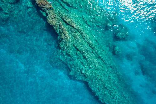Two Tiny Little People Explore Coral Reef As Seen From Drone Photo