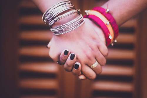 Two People Holding Bangle-Adorned Hands Photo