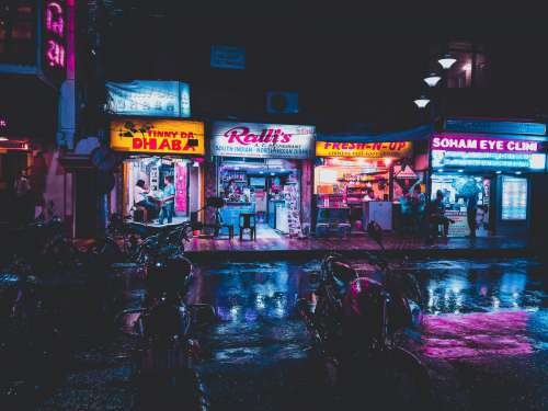 Neon Shop Lights Reflect On Rain-Wet Streets In India Photo