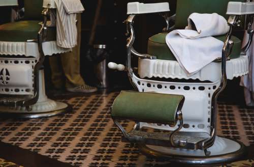 Lower View Of Green And White Chairs In Barbershop Photo
