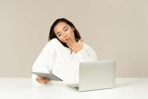 Gasping Young Asian Woman Talking On The Phone, Using Tablet And Doing Online Shopping