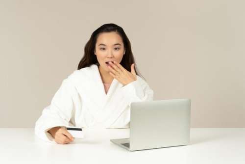 Gasping Young Asian Woman Doing Online Shopping