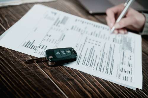 Man signing car insurance document or lease paper