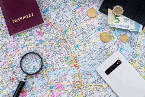 Magnifier on the map with passport, wallet with the money and smartphone