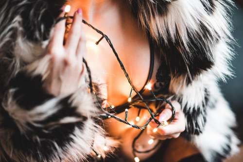 Woman in a Luxury Fur Coat with Christmas Lights Free Photo