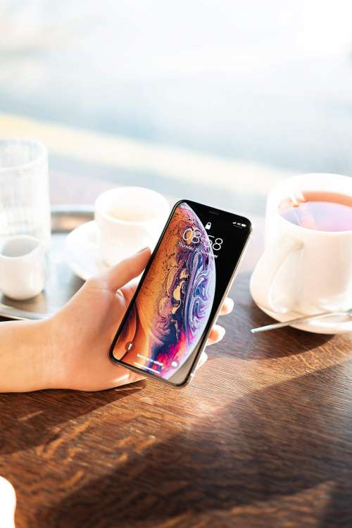 Showing an iPhone XS in Café Free Photo
