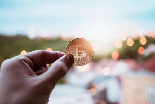 Bitcoin Coin Against an Evening City Free Photo