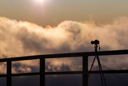 camera silhouette sky tripod clouds