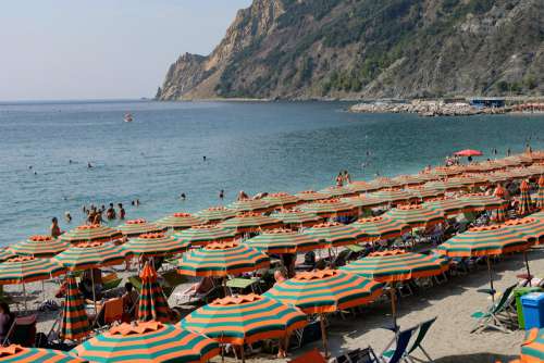 Crowded Beach With Orange and Green Sun Umbrellas at Beach Filled with Sun Umbrellas at Monterosso, Italy