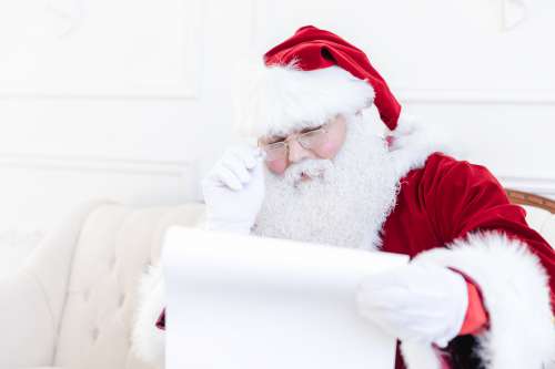 Santa Examines His Naughty Or Nice List Photo