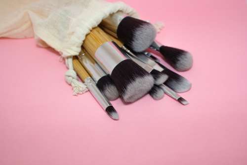 Paintbrushes Of Different Sizes Spill Onto A Pink Table Photo