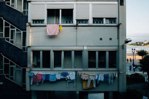 The Grey Face Of An Apartment Block Draped In Clothes Lines Photo