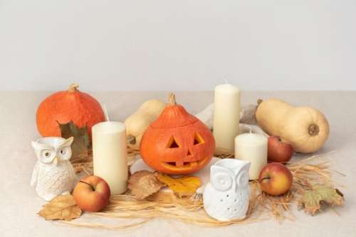Carved Pumpkins, Owls Figures, Candles And Red Apples