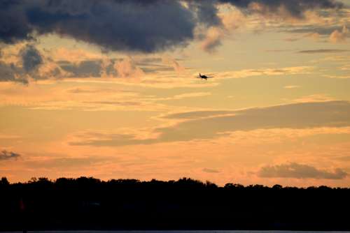 Airplane Flying At Sunset