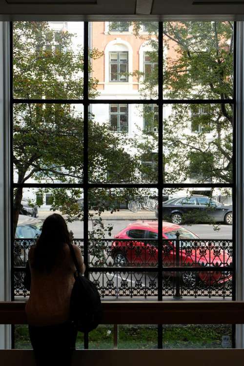 Girl Watching Outside Through a Big Window