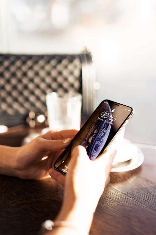 Woman Using a Modern Smartphone in Café Free Photo