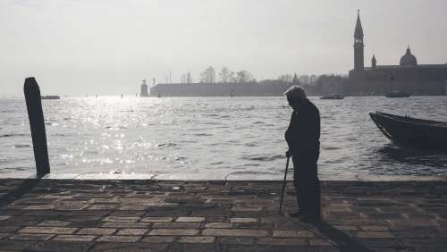 Old Man Thinking By The Harbor Photo