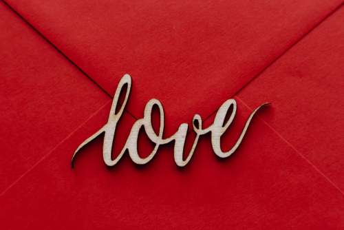 Wooden word love on a red envelope