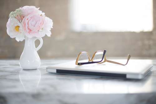 reading glasses desk laptop flowers