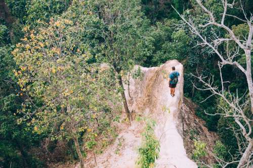 Hiker Navigates A Narrow Rock Face Photo