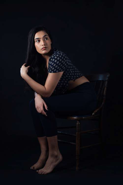 Woman Leaning Forward While Sitting On Wooden Chair Photo