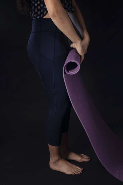 Woman Rolls Up Purple Yoga Mat Photo