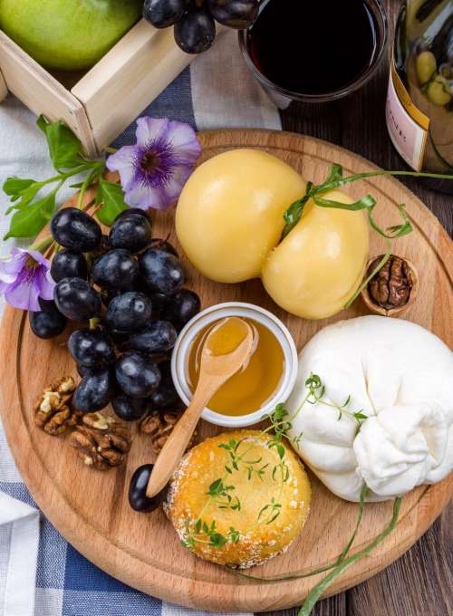 Cheese and fruits on wooden board