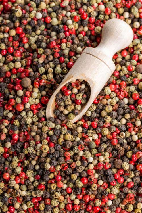 Overhead view of dried pink peppercorn and black pepper