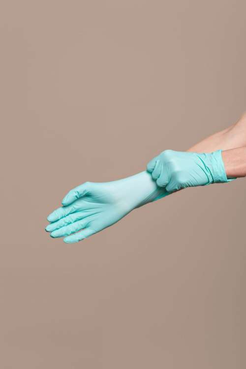 Woman hands putting on a latex gloves