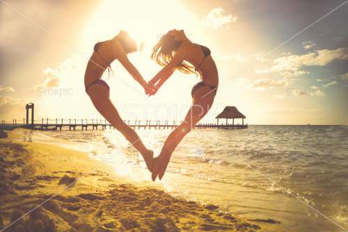 Girls On Beach Jumping To Make Cute Love Heart