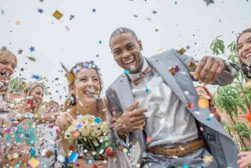 Happy Couple Getting Married With Confetti And Flowers
