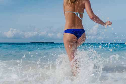 Girl Running Into Ocean Wearing Bikini Bottoms