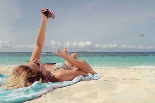 Girl In Bikini Taking Selfie On The Beach