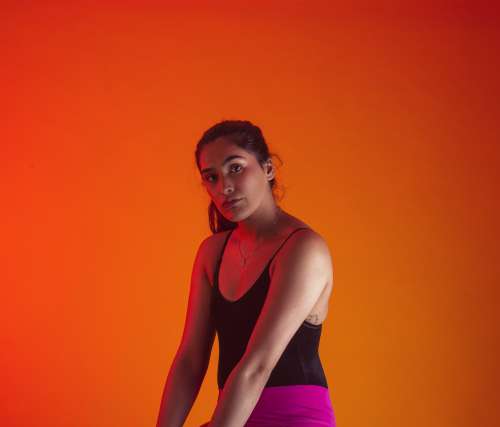 Model Poses Against Orange Background Photo