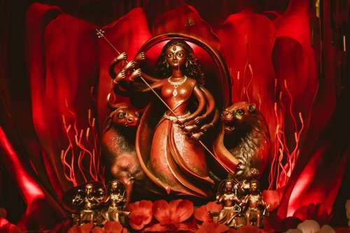 A Carved Figurine On A Red Background Photo