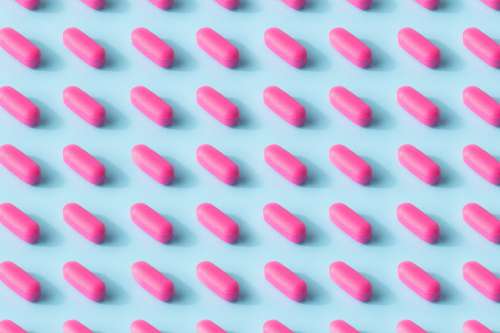 Pink Pill Pattern On A Baby Blue Surface Photo