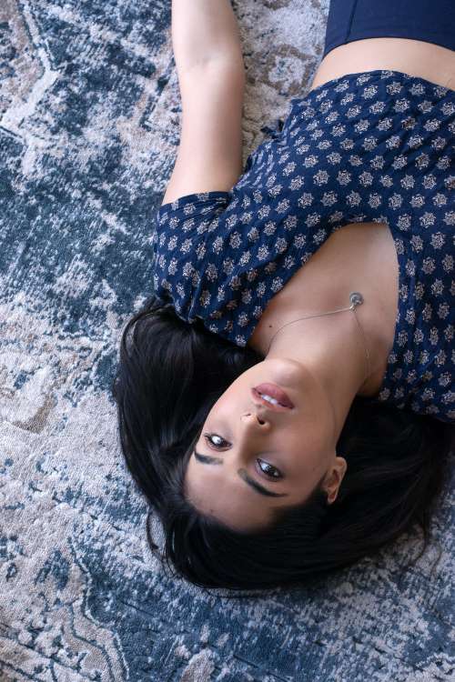 Woman Lies On Patterned Blue Rug Photo