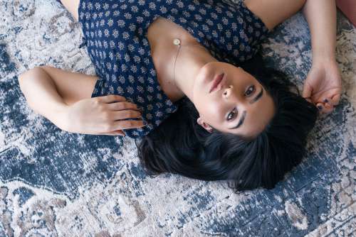 Woman Poses On Blue Patterned Rug Photo